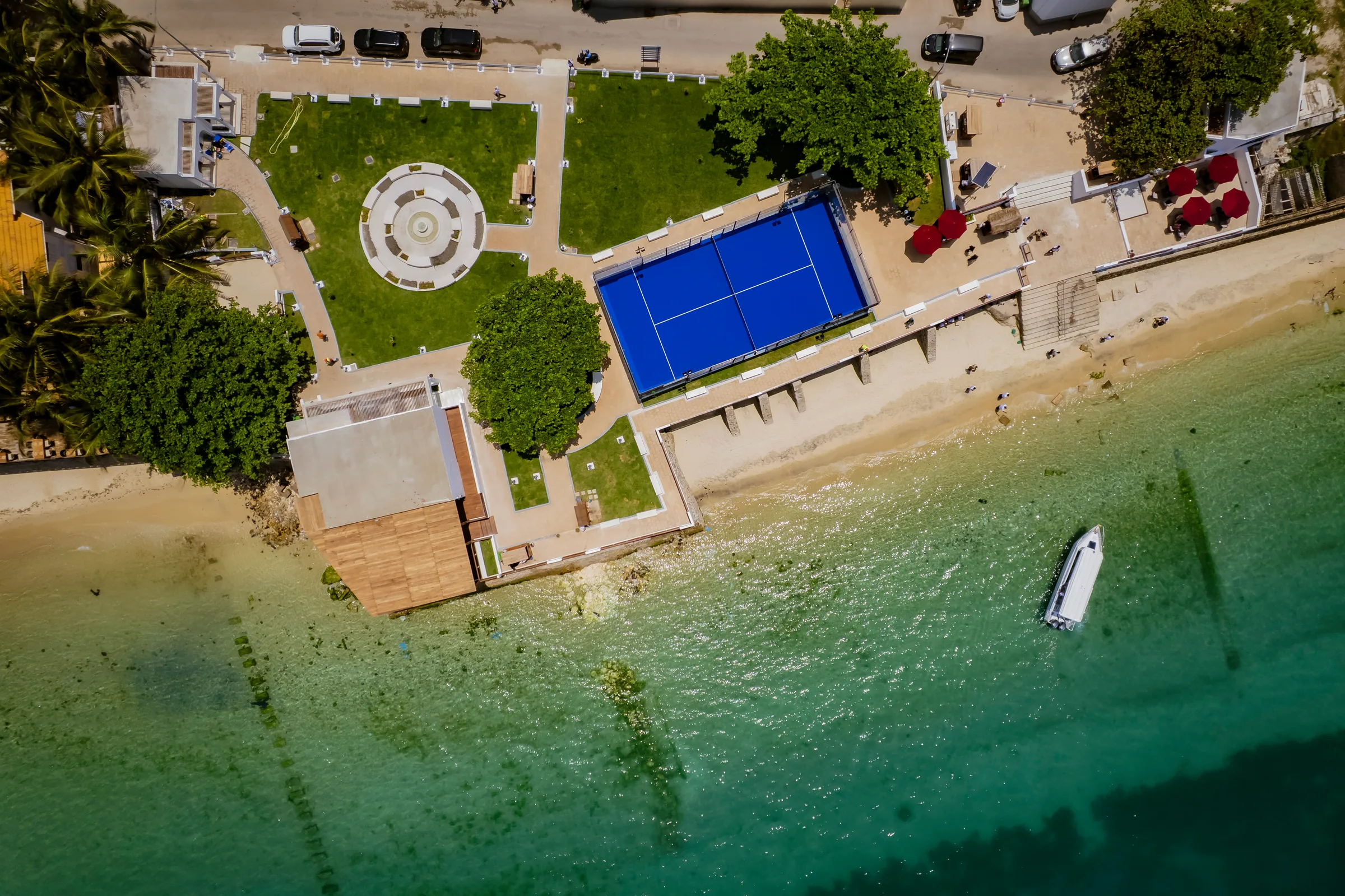 Aerial photograph of the garden lawns, circular seating area and paddle court beside the water